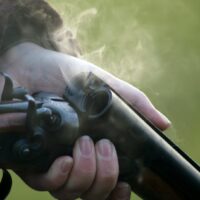 man holding 12 gauge shotgun for sale