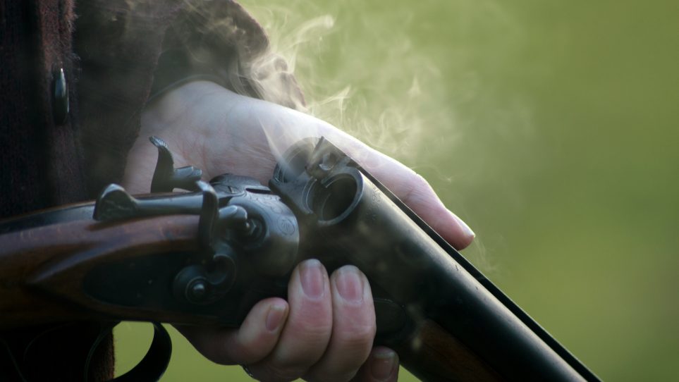 man holding 12 gauge shotgun for sale